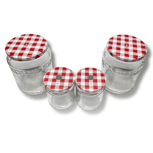 Top view of four empty mushroom growing jars showing modified checkered lids with self-healing injection ports and filters.