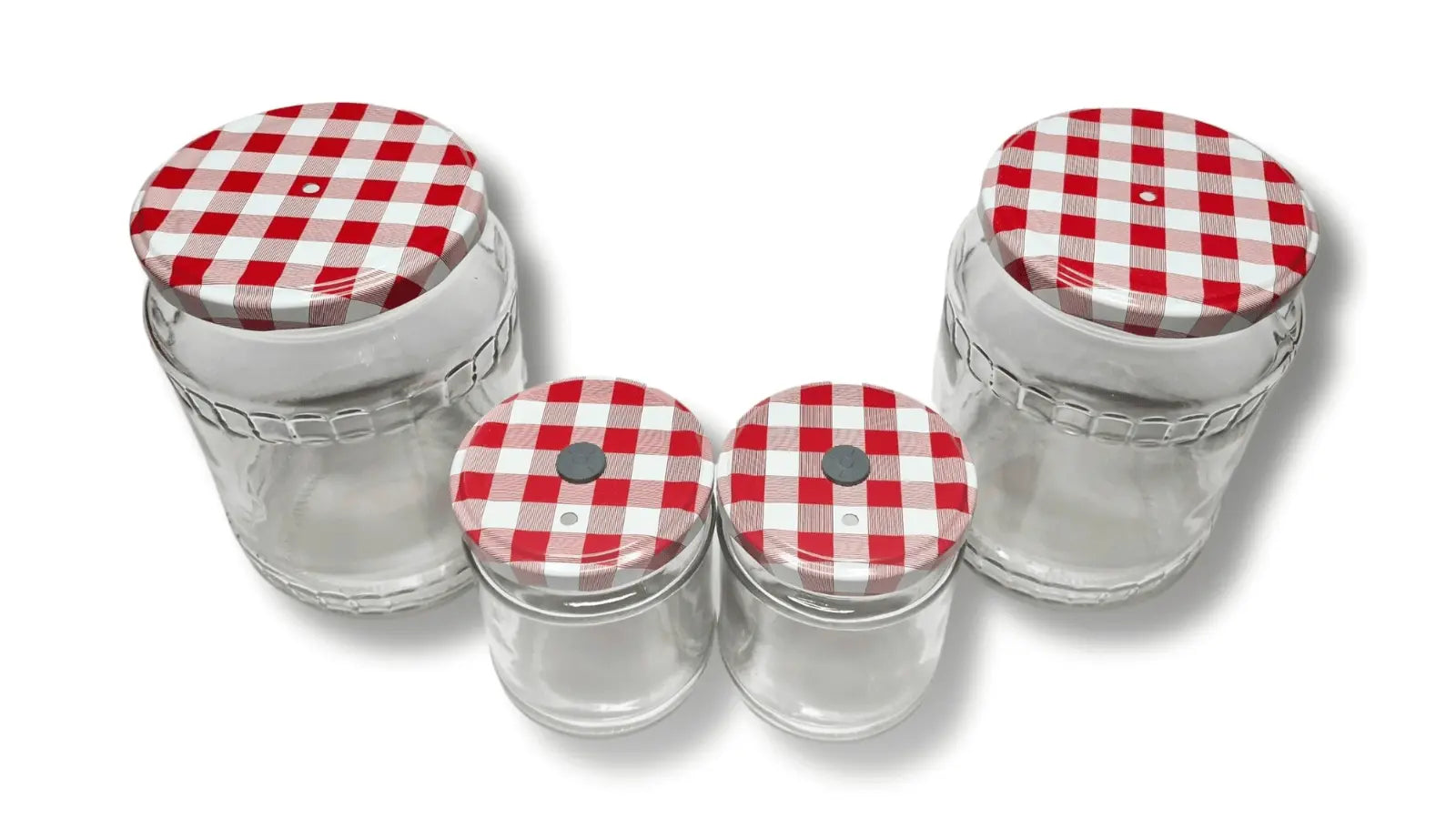 Top view of four empty mushroom growing jars showing modified checkered lids with self-healing injection ports and filters.