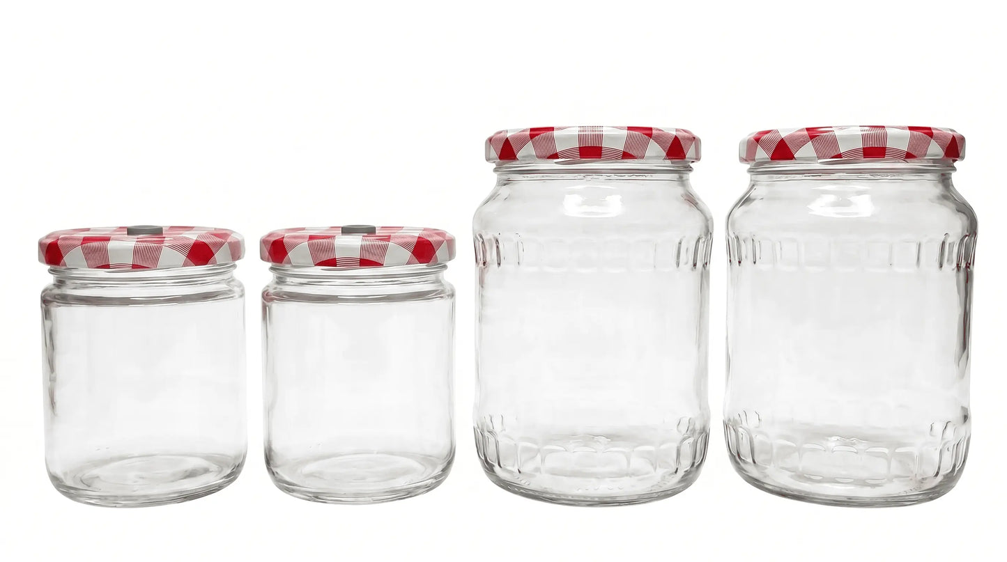 Four empty glass mushroom growing jars in varying sizes with modified red and white checkered lids for inoculation.