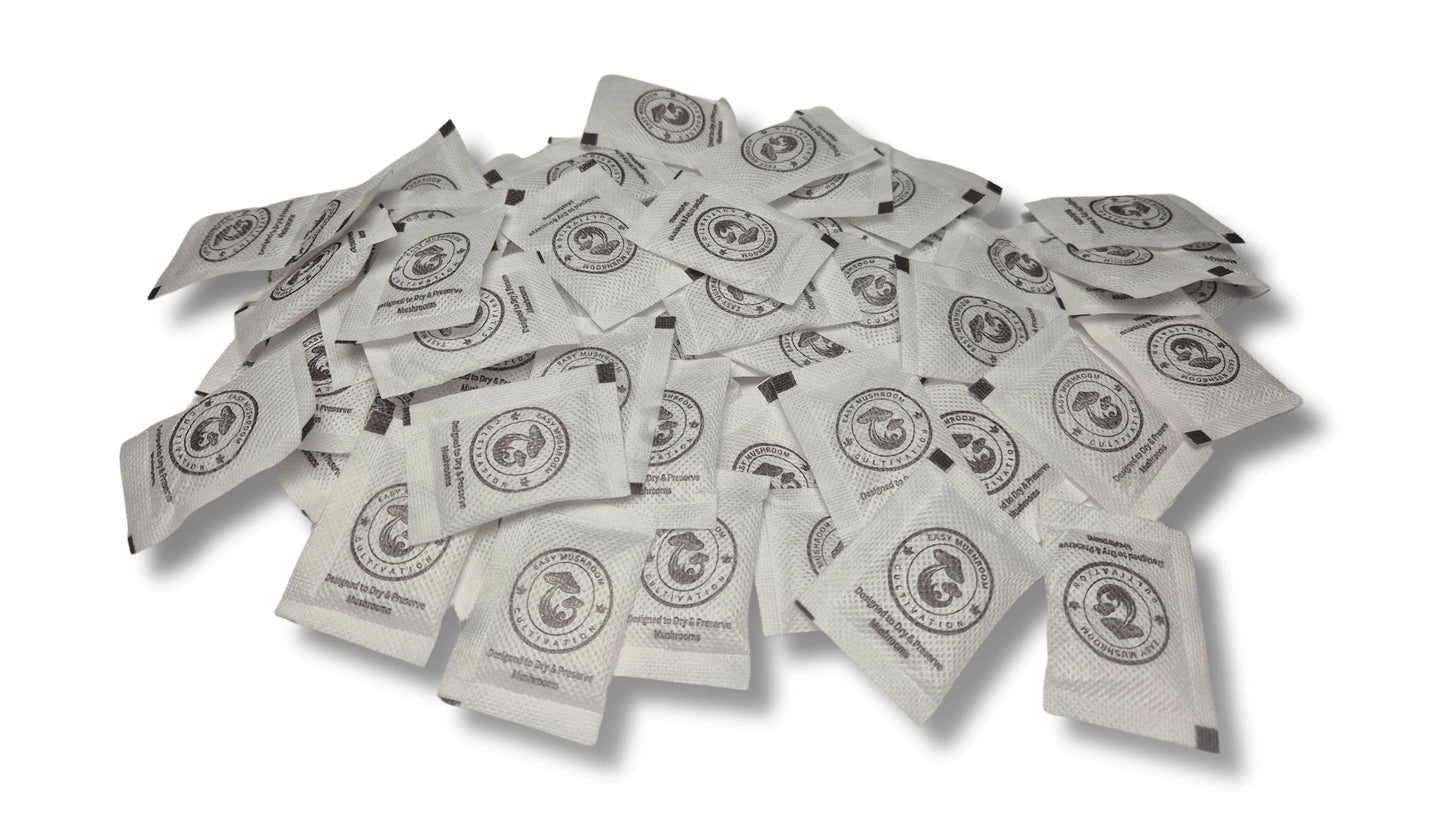 A large, scattered pile of white desiccant packets on a white surface. Every packet displays a circular logo of a mushroom and the brand name "Easy Mushroom Cultivation."