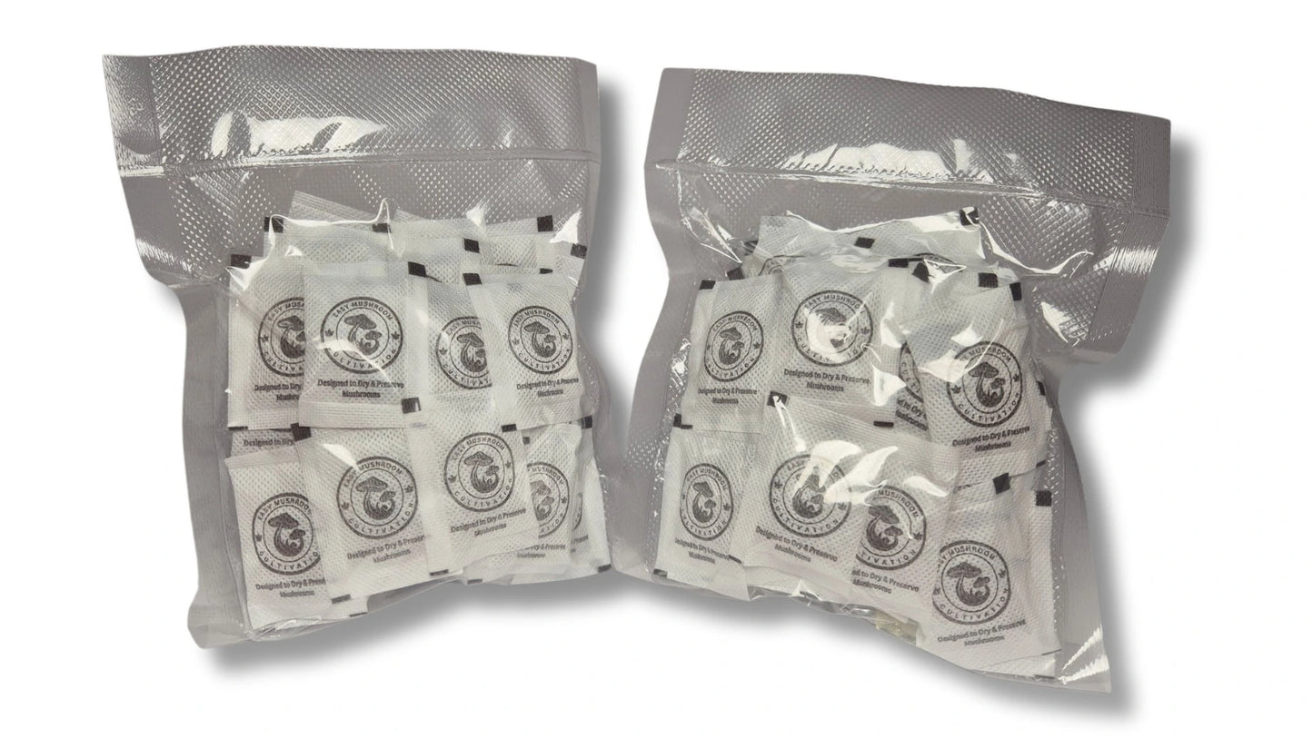 Two clear vacuum-sealed plastic bags filled with numerous small white desiccant packets. Each packet features a circular "Easy Mushroom Cultivation" logo and the text "Designed to Dry & Preserve Mushrooms."